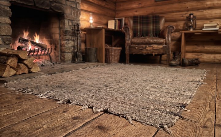 A log cabin with a stone fireplace and a log fire